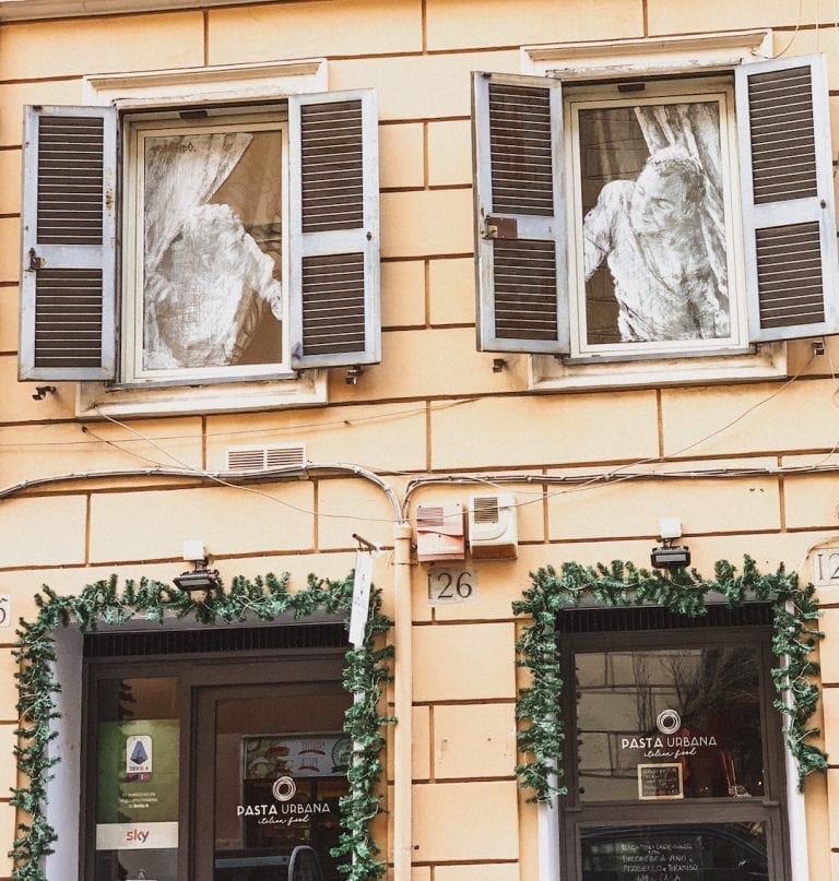 the funny street art about neighbors on the buildings in cavour