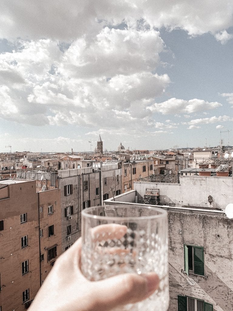 drinking wine on rooftop to enjoy the sunny day in rome while doing quarantine and social distancing in coronavirus situation