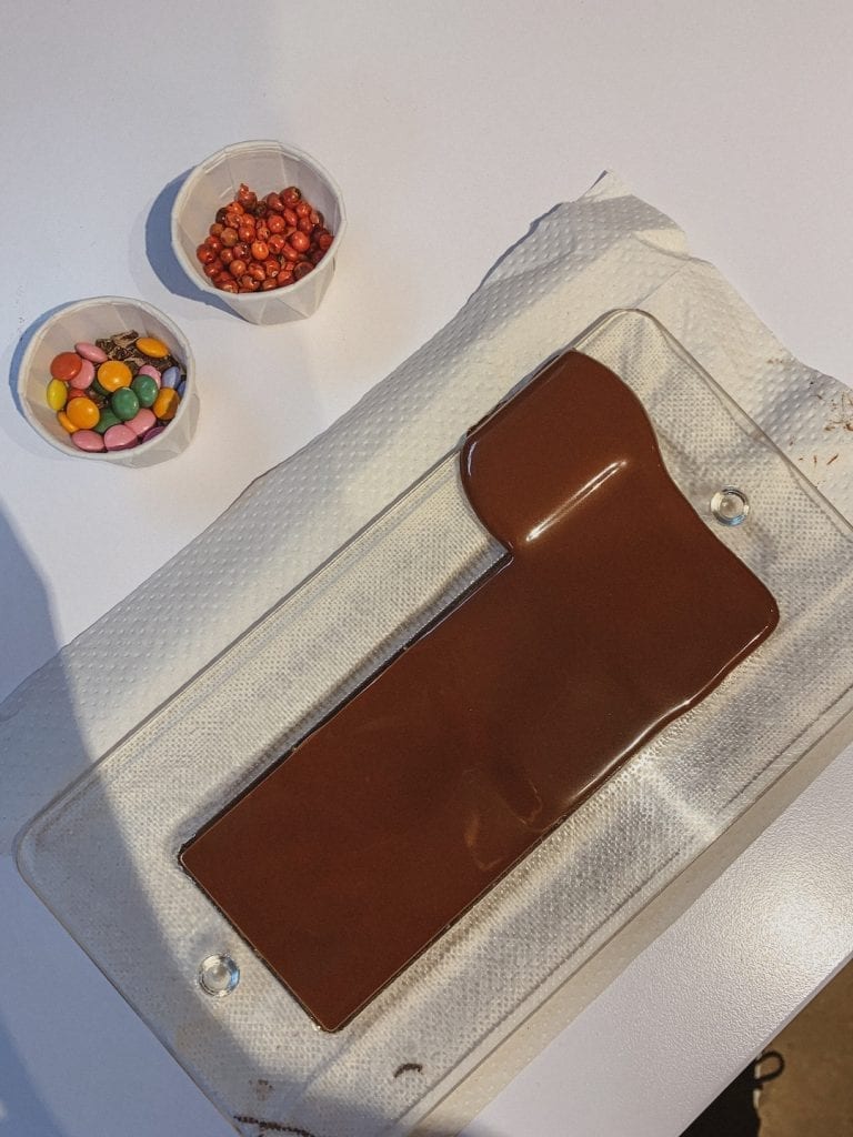 we are given running chocolate with a plastic mold in the chocolate workshop