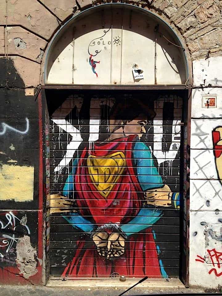 modern superman graffiti on a shop roller shutter in san lorenzo one of the famous art district and Rome street art district