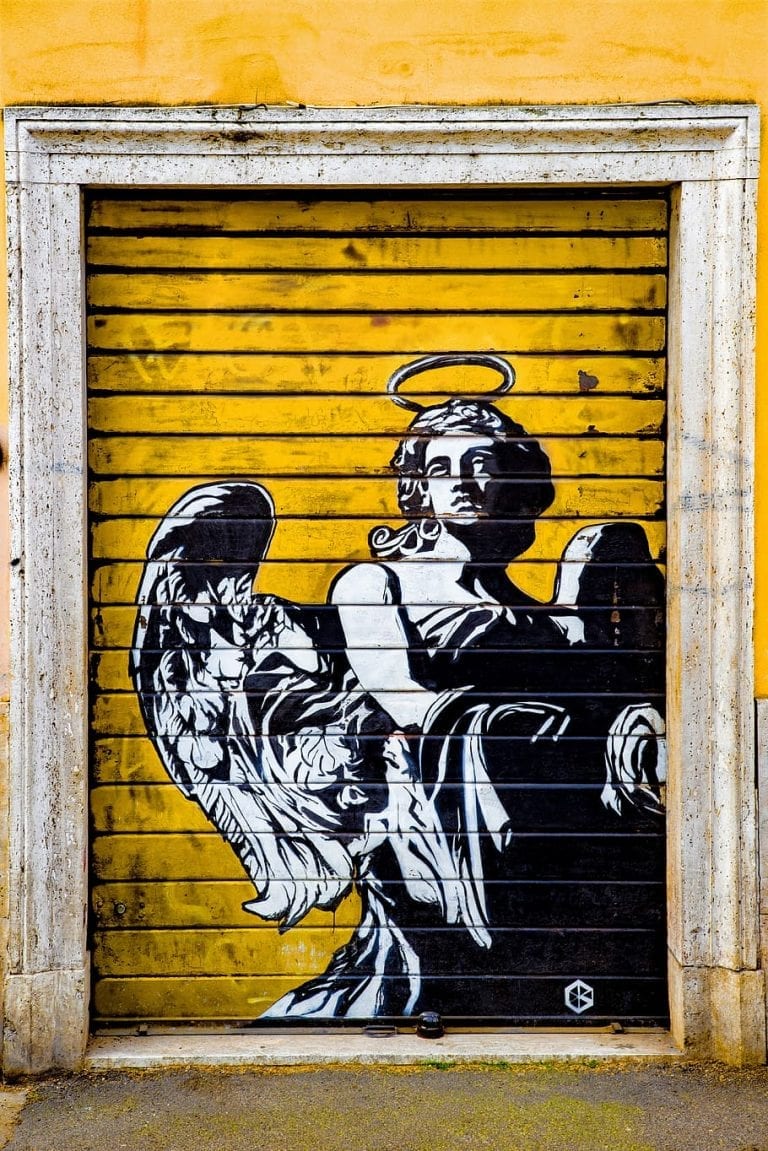 An extra Angel graffiti printed on a shop roller shutter near Ponte Sant Angelo in Rome becomes a hidden Rome street art