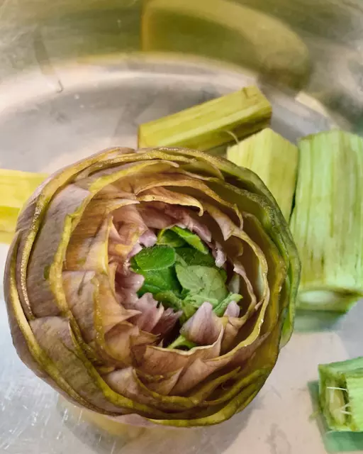 Mentuccia and garlic is a pair when cooking with artichokes. They create a good balance for the rich and fresh taste. Normally you chopped a little and stuff them in the centre of the cleaned artichokes.