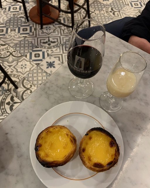night egg tart with a glass of Port wine in Porto city center