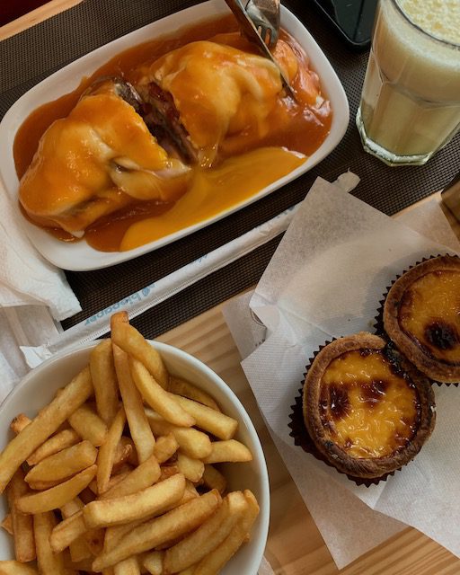 egg tart and Francesinha with French fries in Porto